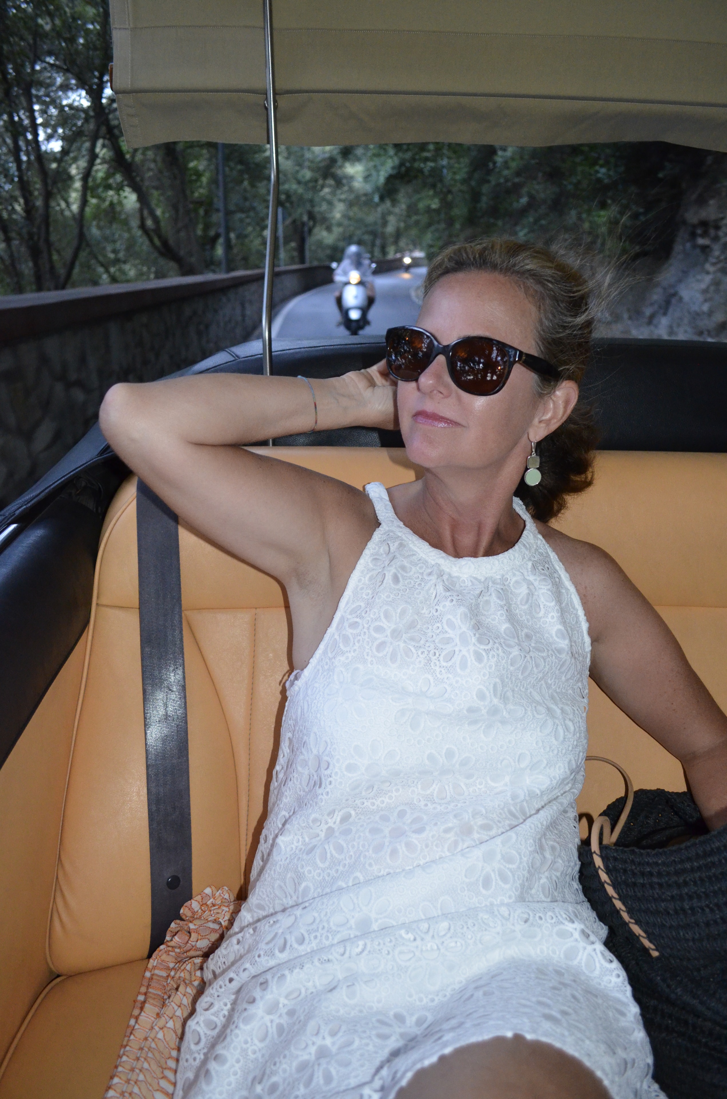 Cindy relaxing in a convertible on a scenic drive