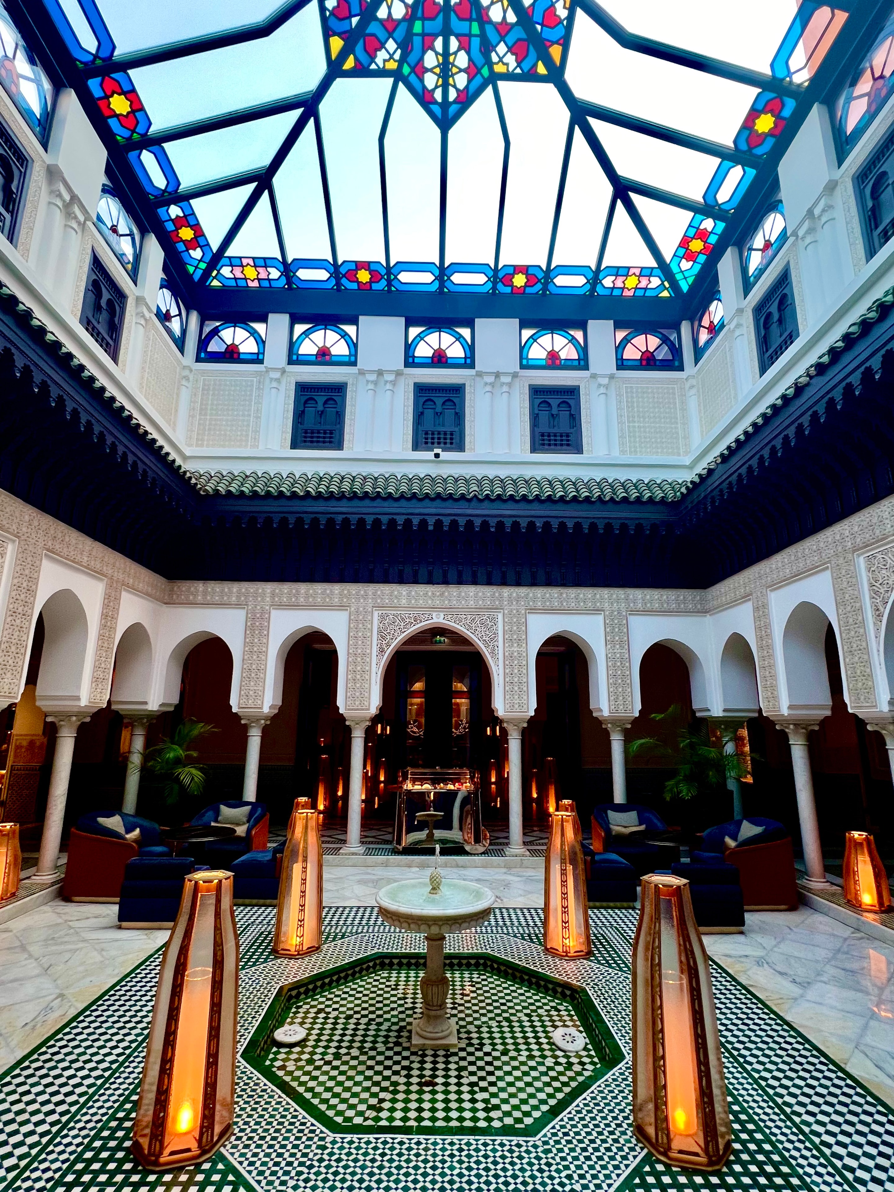 Ornate Moroccan riad courtyard with stained glass ceiling