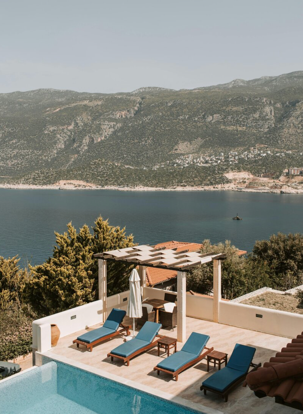 Lounge chairs by a pool with sea view